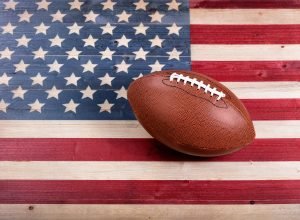 football resting on a rustic painted american flag